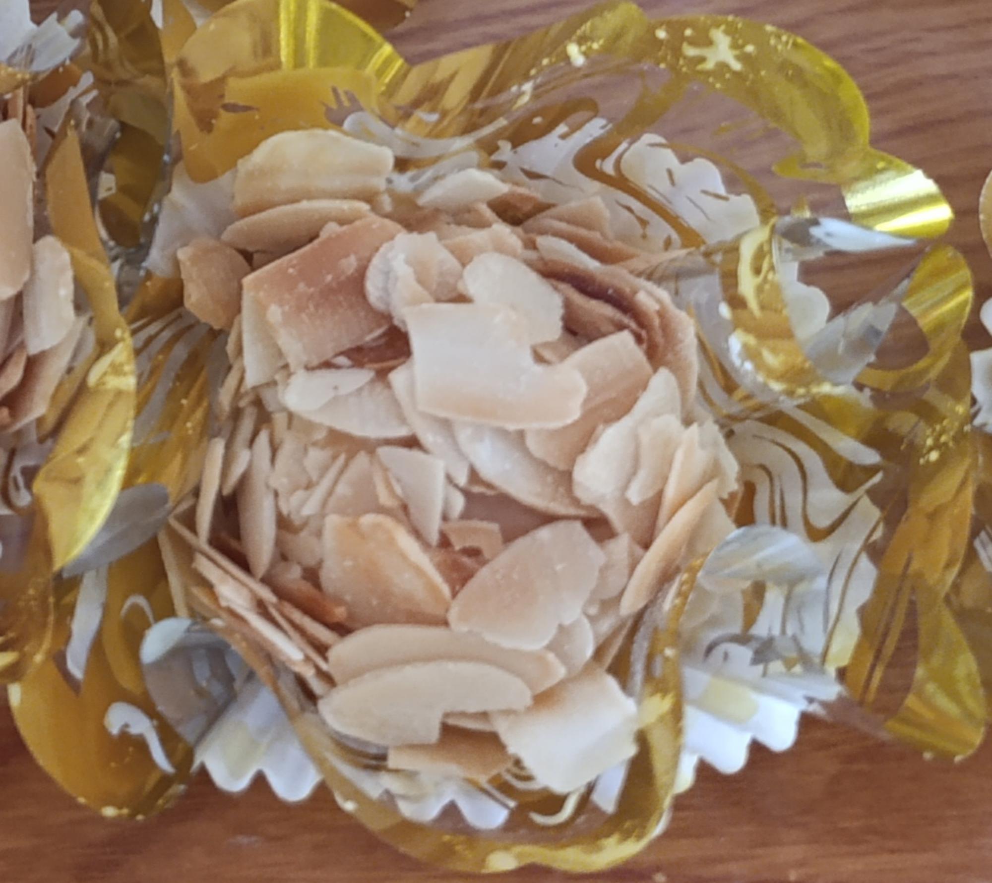 Gateau à base de noix de coco et recouvert de chocolat blanc et d'amandes effilées